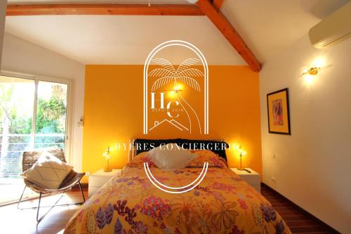 Somptueuse Villa l'Oasis By HC في كاركيران: غرفة نوم مع سرير مع علامة على الحائط