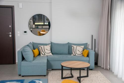 un soggiorno con divano blu e specchio rotondo di eugea apartments a Città di Lefkada