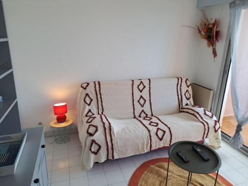 - un salon avec un canapé et une lampe rouge dans l'établissement La Brigantine 592, Superbe vue pour ce T2 avec piscine., au Cap d'Agde