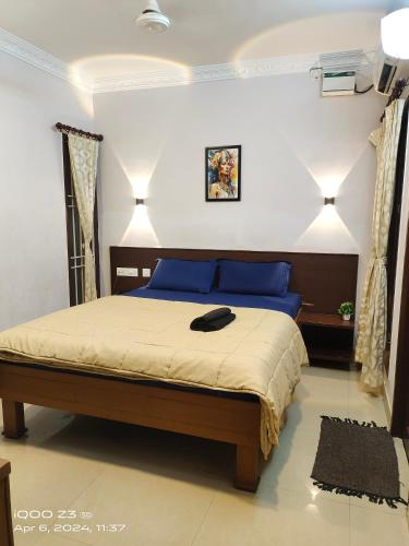Nest Inn في بونديتْشيري: غرفة نوم مع سرير مع قبعة سوداء عليه