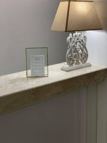 a table with a lamp and a picture on it at Hotel AVENUE in Ravda