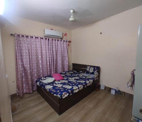 a bedroom with a bed with a purple curtain at Classic Riverain in Haldia