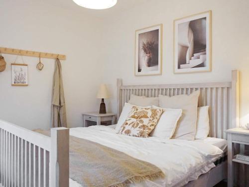 Una cama con sábanas blancas y almohadas en un dormitorio en Holiday home Smögen IV, en Smögen