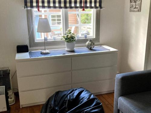 - une commode avec une fenêtre dans le salon dans l'établissement Holiday home ODENSBACKEN IV, à Stora Mellösa