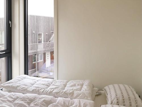 an unmade bed in a room with a window at 6 person holiday home in Søndeled in Søndeled