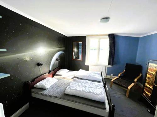 a bedroom with a bed and a chair in it at Holiday home FREDRIKSBERG III in Fredriksberg