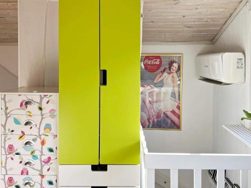 Armario amarillo en una habitación con nevera en Holiday home EKERÖ, en Ekerö