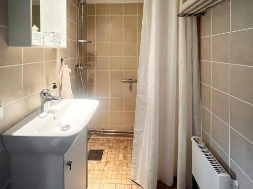 uma casa de banho com um lavatório e uma cortina de chuveiro em Holiday home VÄXJÖ II em Växjö