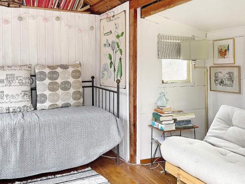 ein Schlafzimmer mit einem Bett, einem Sofa und einem Stuhl in der Unterkunft Holiday home VAXHOLM II in Vaxholm