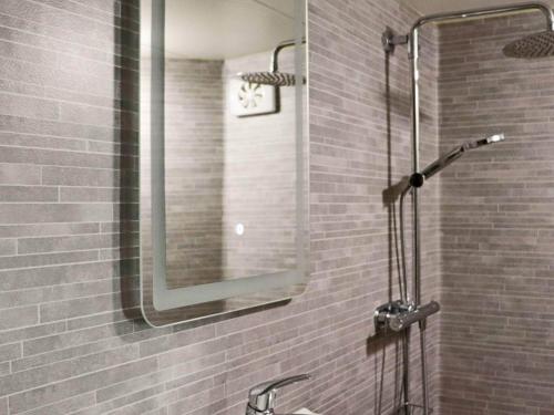 a shower with a mirror and a sink in a bathroom at 4 person holiday home in FALKENBERG-By Traum in Falkenberg