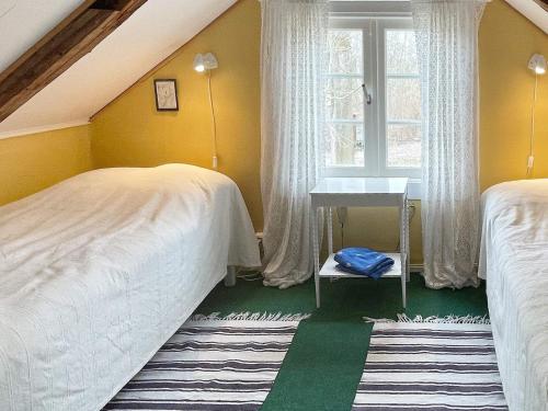 a bedroom with two beds and a sink and a window at Holiday home Ronneby XV in Ronneby