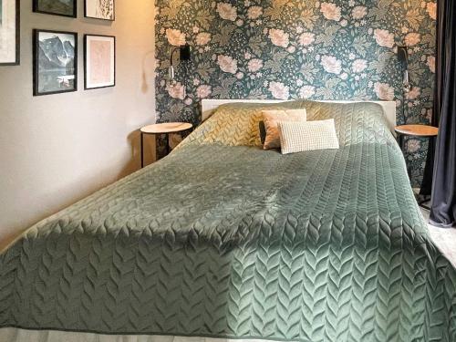 een slaapkamer met een bed met een groen dekbed bij Holiday home Ronneby XIV in Ronneby