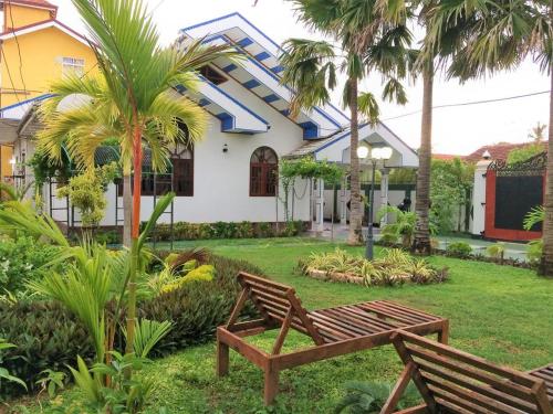 a wooden bench in front of a house at Romeo and Juliet Guest House in Negombo