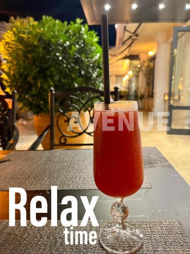 a drink in a glass sitting on a table at Hotel AVENUE in Ravda