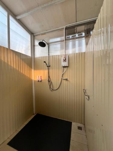a gym room with a shower with a black floor at Villa88 in San Kamphaeng