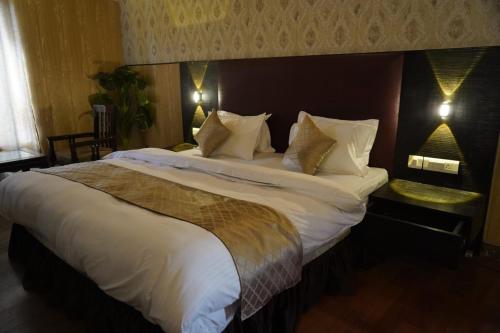 a bedroom with a large bed with white sheets and pillows at Vacay inn Hotel in Nainital