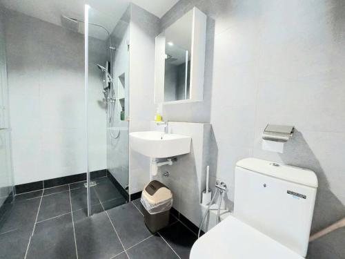 La salle de bains blanche est pourvue de toilettes et d'un lavabo. dans l'établissement Jesselton Quay Citypads Kota Kinabalu, à Kota Kinabalu