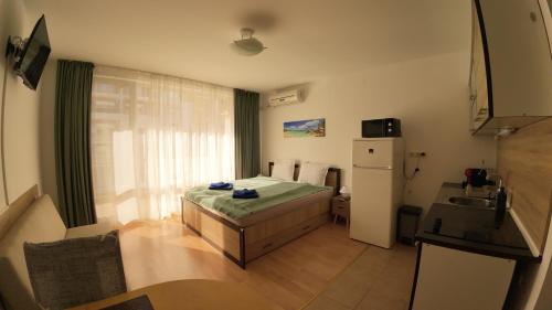 a small room with a bed and a refrigerator at William's fourth pretty studio-Crown Fort Noks in Sveti Vlas