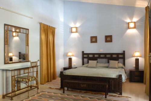 瑞詩凱詩的住宿－Ayurveda Bhavan，一间卧室配有一张床和一面大镜子