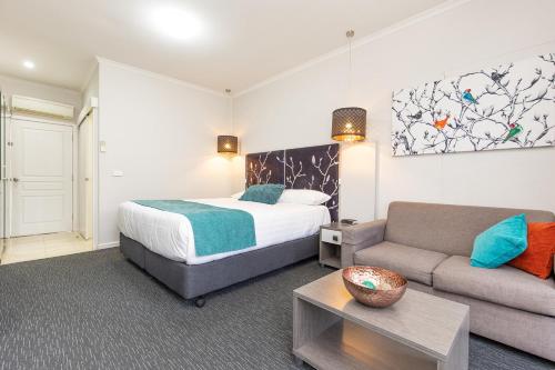 Habitación de hotel con cama y sofá en Comfort Inn Deakin Palms, en Mildura