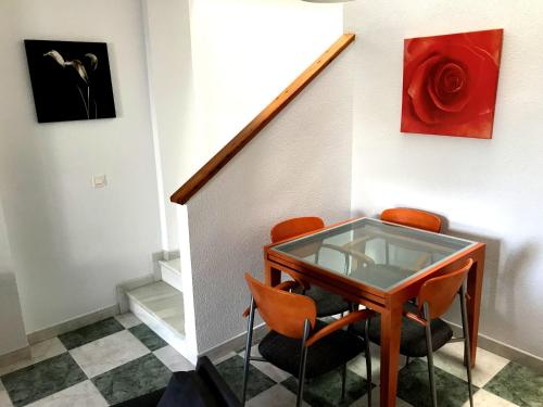 een kamer met een glazen tafel en oranje stoelen bij Mediterranea 6 Las Conchas junto al mar in Vera