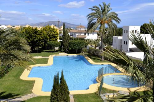 een zwembad in een resort met palmbomen en gebouwen bij Mediterranea 6 Las Conchas junto al mar in Vera