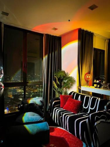 - un salon avec un canapé et une fenêtre dans l'établissement HMJ4 2BR stylish apartment on 36th floor KKC City center, à Khon Kaen