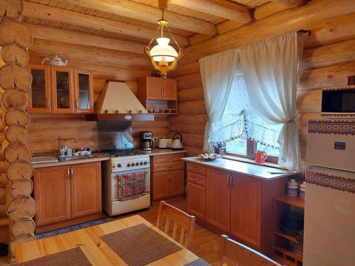 a kitchen with wooden cabinets and a stove and a window at Cabana Razesilor in Gura Humorului