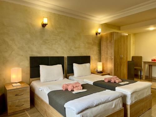 um quarto com 2 camas com toalhas cor-de-rosa em The Hill Guest House em Yerevan