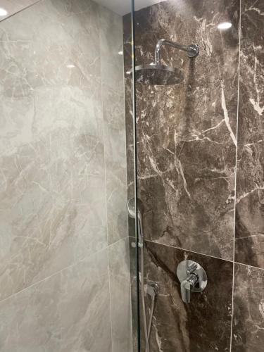 a bathroom with a shower with a glass door at Hotel AVENUE in Ravda