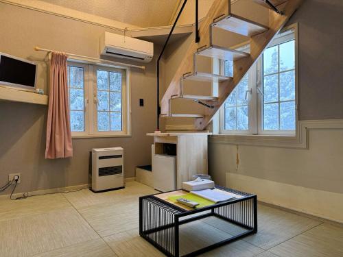 ein Zimmer mit einer Treppe und einem Tisch darin in der Unterkunft Hakuba Sun Valley Hotel Annex in Hakuba