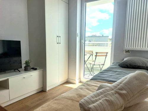 a bedroom with a bed and a tv and a balcony at Royal Smart Apartments Cracow in Kraków