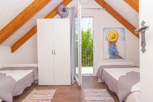 a bedroom with two beds and a window at Kuća za odmor Laurus s bazenom in Kukljica