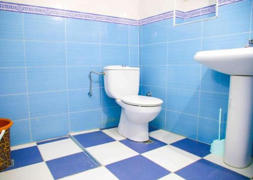 uma casa de banho em azulejos azuis com um WC e um lavatório em Silius em Chefchaouen