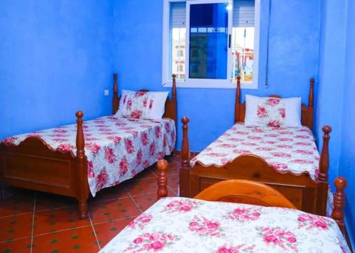 um quarto com 2 camas e uma parede azul em Silius em Chefchaouen