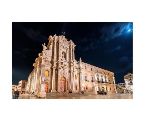 a large building is lit up at night at I SARACENI in Syracuse