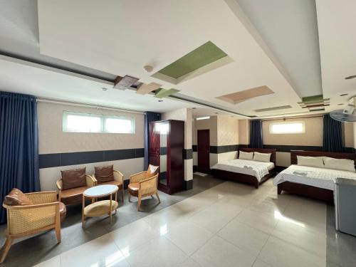 um quarto de hospital com duas camas e uma mesa e cadeiras em Khách sạn Sài Gòn em Ho Chi Minh
