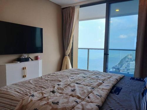 喬木提恩海灘的住宿－Copacabana Luxury sea-view room with infinity pool01，一间卧室设有一张床和一个大窗户