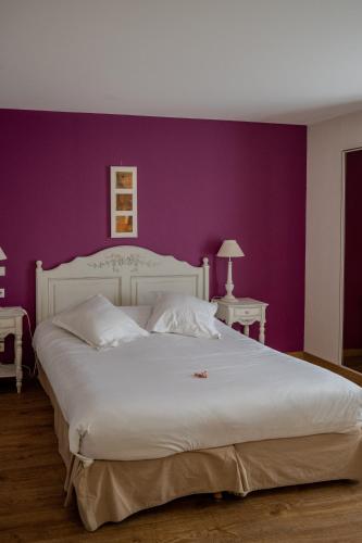 a bedroom with a large white bed with purple walls at Tulip Inn Honfleur Residence & Spa in Honfleur