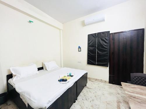 a bedroom with a large bed with white sheets at Hotel Maharaja - Majnu-ka-tilla in New Delhi