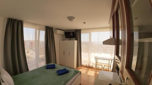 a bedroom with a bed and a large window at William's apartments - second cozy studio in Sveti Vlas