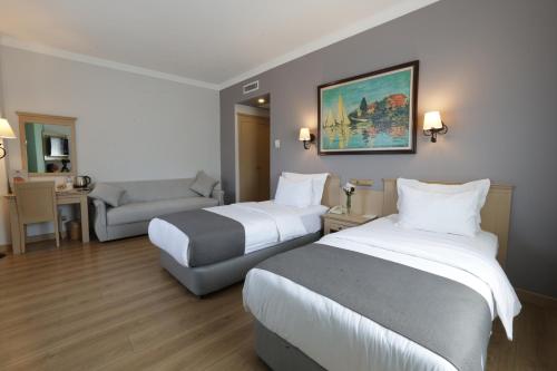 una habitación de hotel con 2 camas y una silla en Usta Park Hotel, en Trabzon