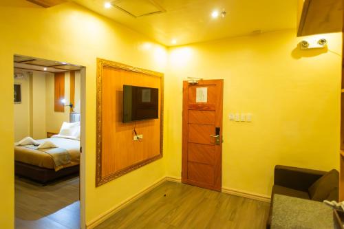 Habitación con puerta, cama y espejo en Raim Hotel, en Pagadían​