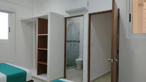 a bathroom with a toilet and a glass door at Condominio Aeromar in Acapulco
