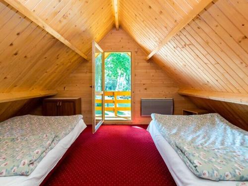 a attic room with two beds and a window at Holiday house for 5 people, Jaros awiec in Jarosławiec