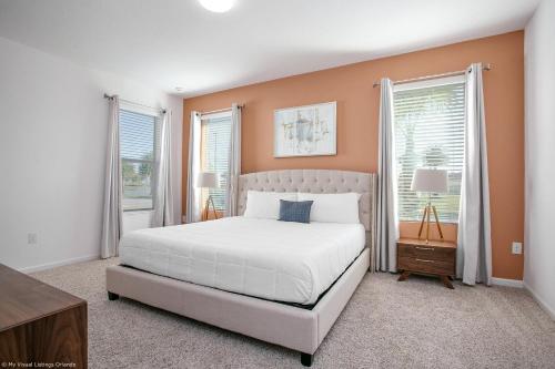 Un dormitorio con una cama blanca y dos ventanas. en Sonoma Resort 7 Bedroom Vacation Home with Pool 1849, en Kissimmee