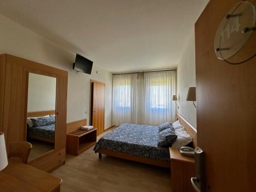 - une chambre d'hôtel avec un lit et un miroir dans l'établissement Hotel Ponte Molo, à Porto Tolle
