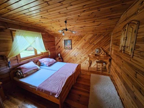 1 dormitorio con 1 cama en una cabaña de madera en Drzemalik wypoczywaj z KLASĄ, en Mikołajki Pomorskie