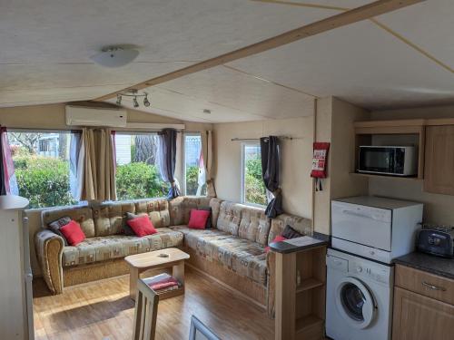 - un salon avec un canapé dans une caravane dans l'établissement MOBIL HOME SPACIEUX 608 village SIBLU LA RESERVE, à Gastes
