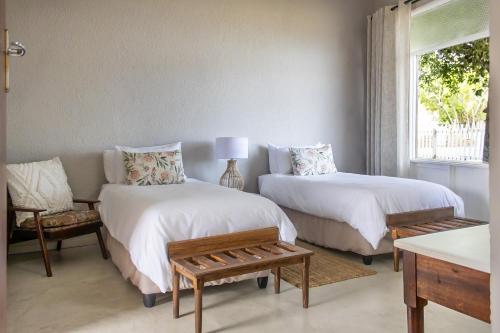 a bedroom with two beds and a couch and a window at Brinkley's River Village in Klein Brak Rivier